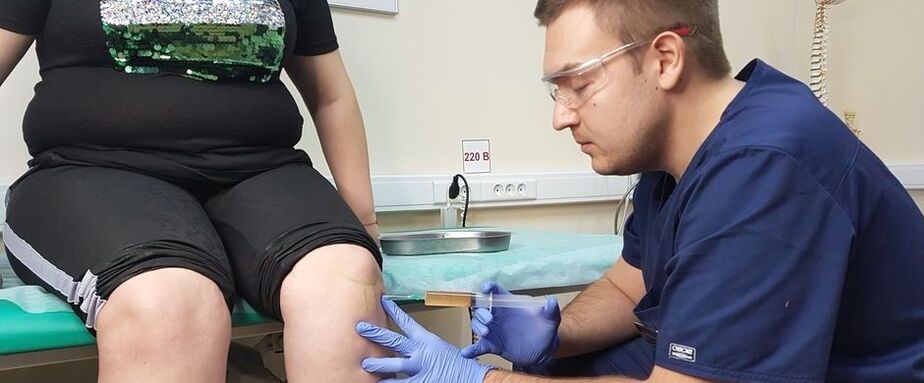 Ortopedický lékař provádí intraartikulární injekci do kolenního kloubu pro osteoartrózu